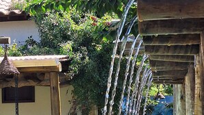 A water feature with cascading streams, a tiled pathway, and lush greenery.