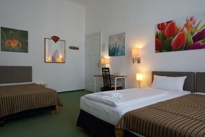 A hotel room with two beds, a desk, and a chair. There are wall-mounted lamps and artwork. - Hotel Ambert (Berlin)