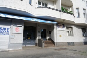 A hotel entrance with a sign reading "HOTEL AMBERT" and a blue awning above the door. - Hotel Ambert (Berlin)