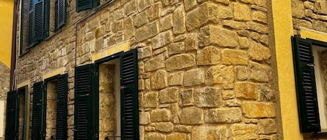 Un edificio de piedra con múltiples ventanas y contraventanas.