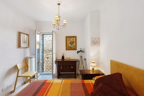 A bedroom with a bed, a chair, a dresser, a lamp, and a painting on the wall. - Apartment 'Sole' with Wi-Fi (Cipressa)
