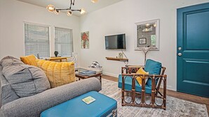 Una sala de estar con sofá, sillón y una mesita con televisor.