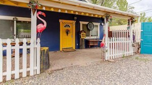 A house with a yellow door, a white picket fence, and a pink flamingo decoration. - Hatter House Flagstaff (Flagstaff)