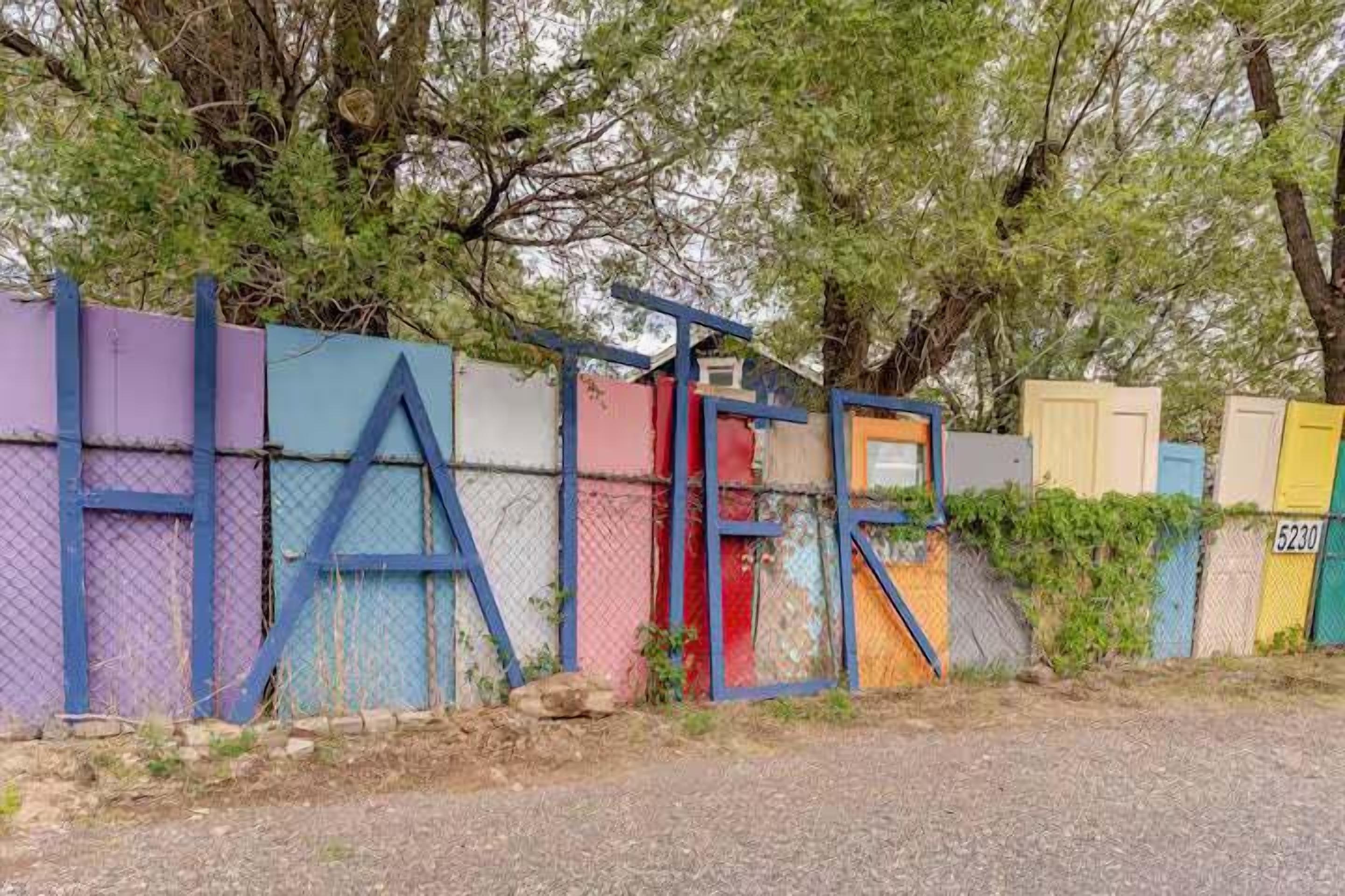 A colorful fence with the word "HAIR" spelled out in large letters.