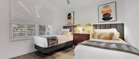 Une chambre moderne avec deux lits, un ventilateur de plafond et des œuvres d’art accrochées aux murs.