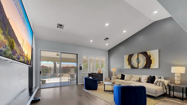 A modern living room with a flat-screen TV, a sofa, a coffee table, and a painting on the wall. - Juniper Scottsdale (Scottsdale)