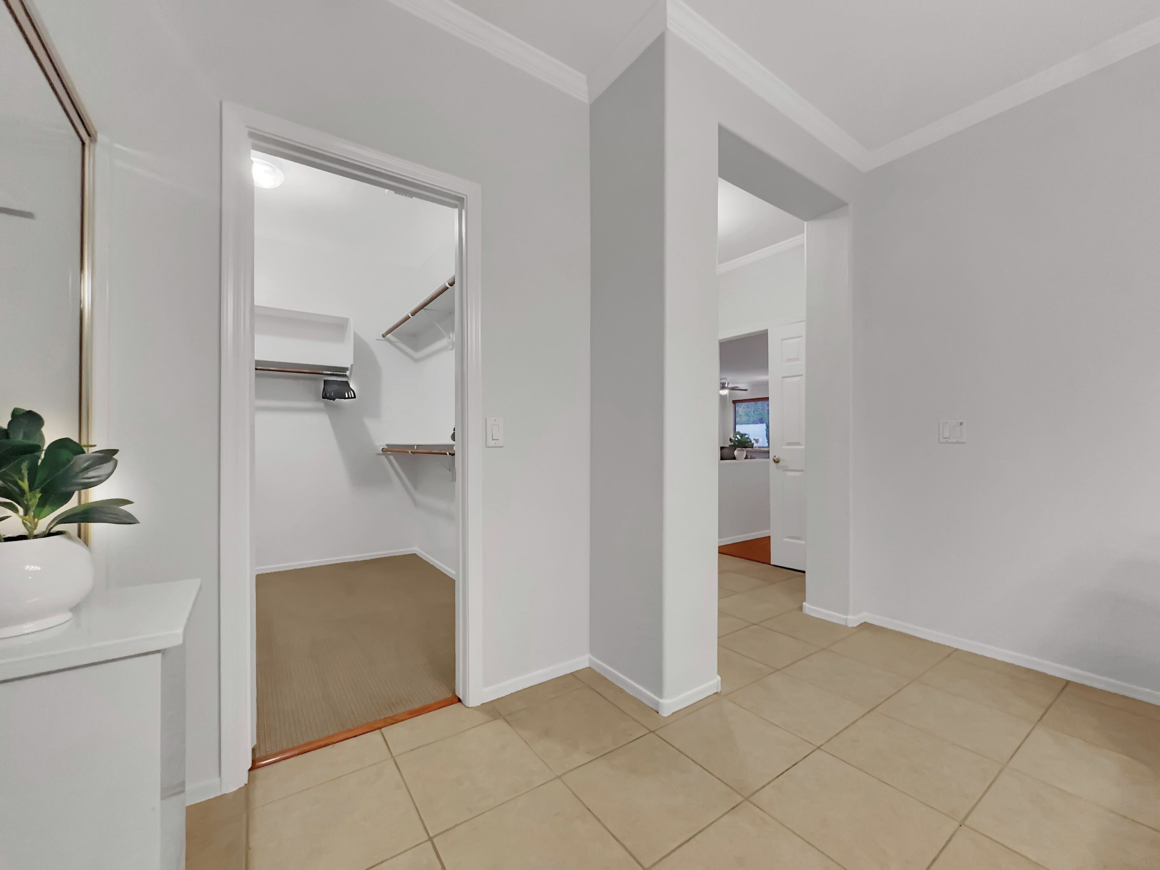 A hallway with a white door leading to a kitchen area.