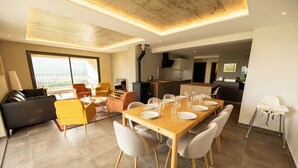 Una sala de estar moderna con comedor, cocina y un balcón con vistas.