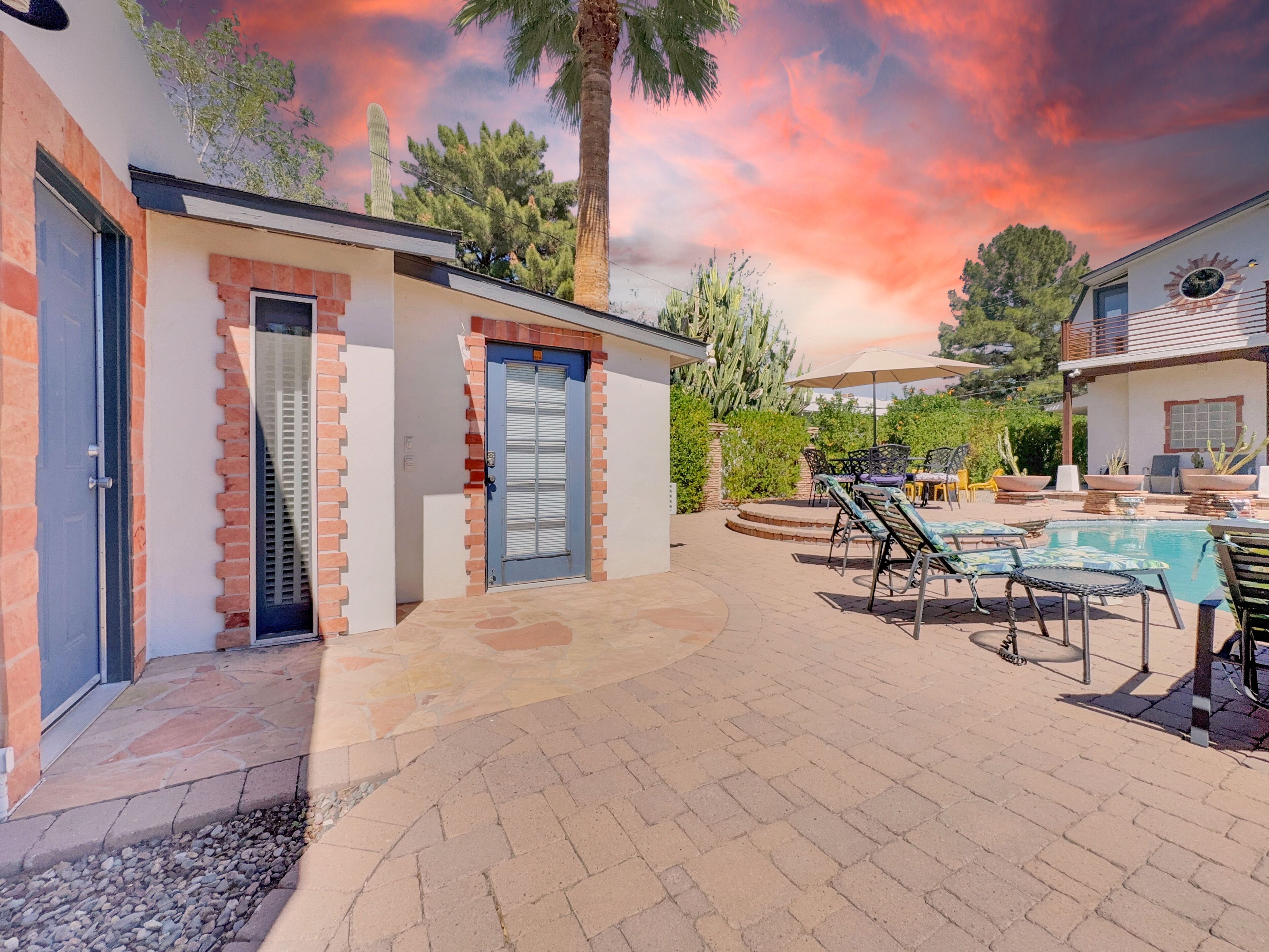 A patio area with a pool, outdoor furniture, and a brick wall.