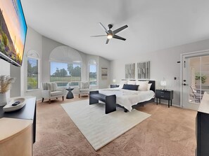 A modern bedroom with a large bed, two armchairs, a desk, and a ceiling fan. - Oleander Ocotillo Chandler Complex (Chandler)
