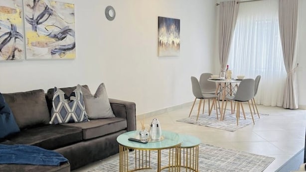 A modern living room with a sofa, coffee table, and dining area.