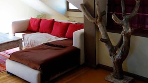 Un soggiorno moderno con un divano, un tavolino da caffè e un'originale scultura a forma di albero.