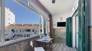 A balcony with a table, chairs, and a view of buildings. - Apartment 'El Portil' with Shared Pool, Wi-Fi and Air Conditioning (El Portil)