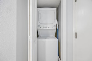 A compact laundry room with a washing machine and dryer. - 2BR Beachfront Boardwalk Condo (Myrtle Beach)