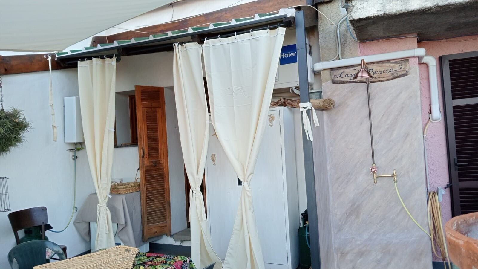 A room with a bed, a window with a curtain, a wooden door, and a wall-mounted heater.
