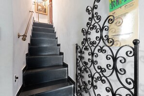 A staircase with black steps and a decorative wrought iron railing.