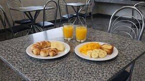 A breakfast table with croissants, cheese, fruit, and juice. - Hotel Royal - Rubiataba (Rubiataba)