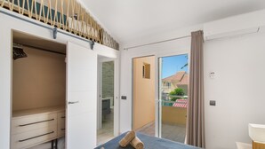 Ein Hotelzimmer mit Bett, Schrank, Badezimmer und einem Balkon mit Blick.