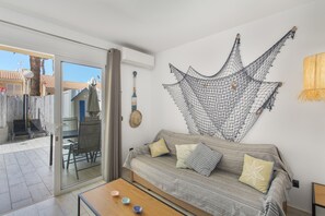 En stue med sofa, sofabord og en vægdekoration i net.