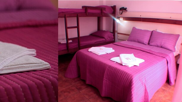 Una stanza con letti a castello e un letto singolo, entrambi con biancheria rosa. Ci sono degli asciugamani sui letti.