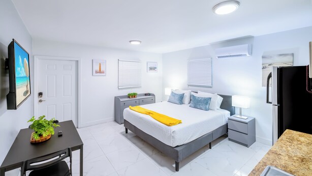 A modern bedroom with a bed, bedside tables, a desk, and a chair.