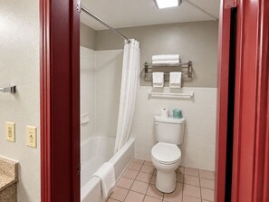 A bathroom with a bathtub, toilet, and shower curtain. - expressway inn (Nashville)