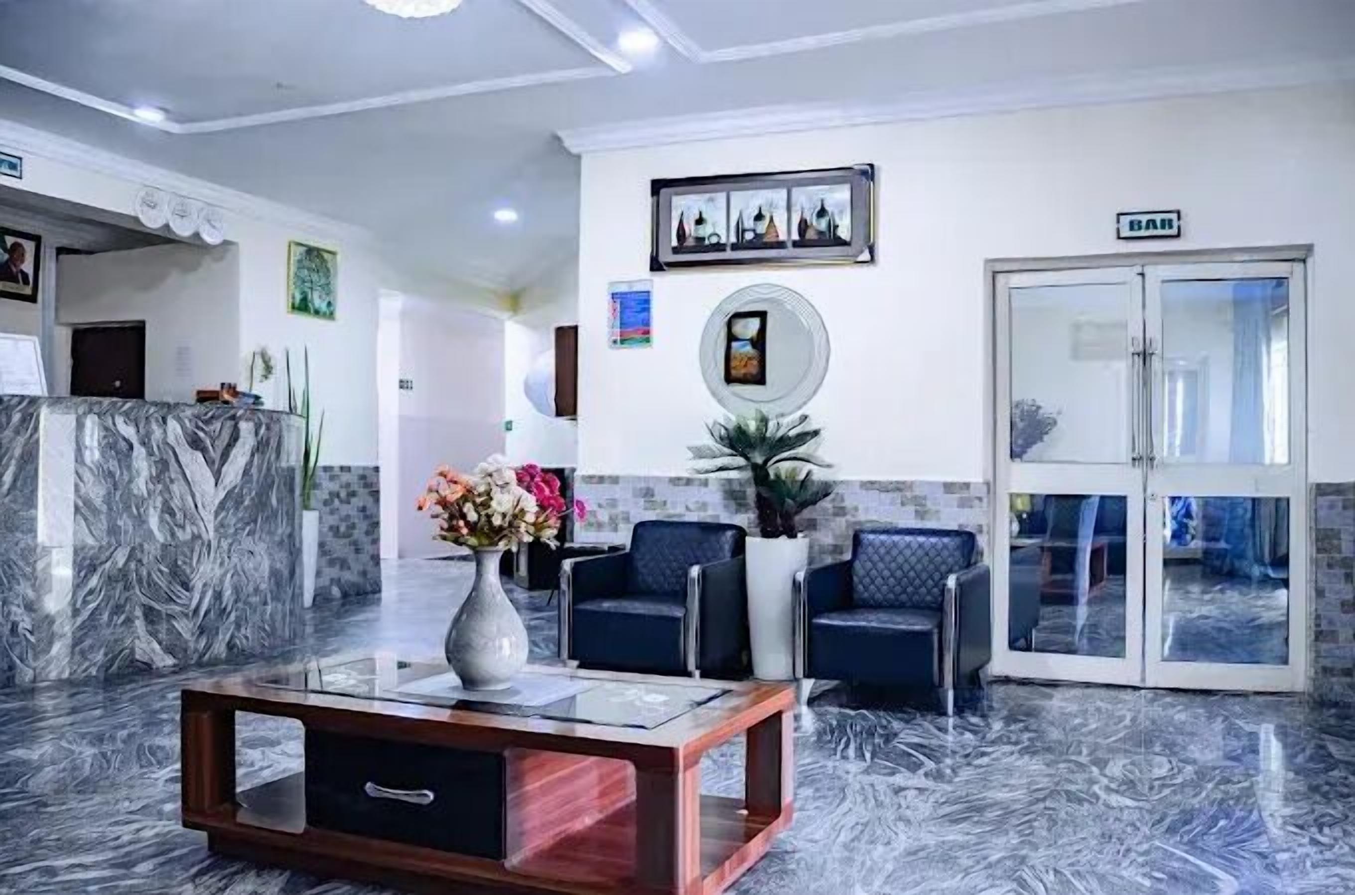 A lobby with a reception desk, seating area, and a glass door entrance.