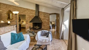 Una sala de estar con chimenea, un sofá, una mesa de centro y un televisor.