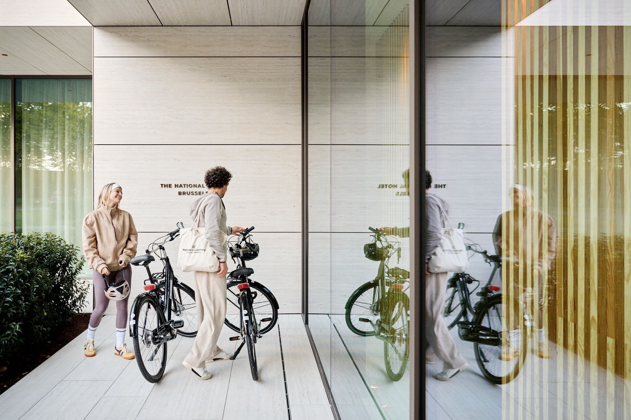 Dos bicicletas estacionadas frente a un edificio con un letrero que dice 'THE NATIONAL BRUSSELS'.