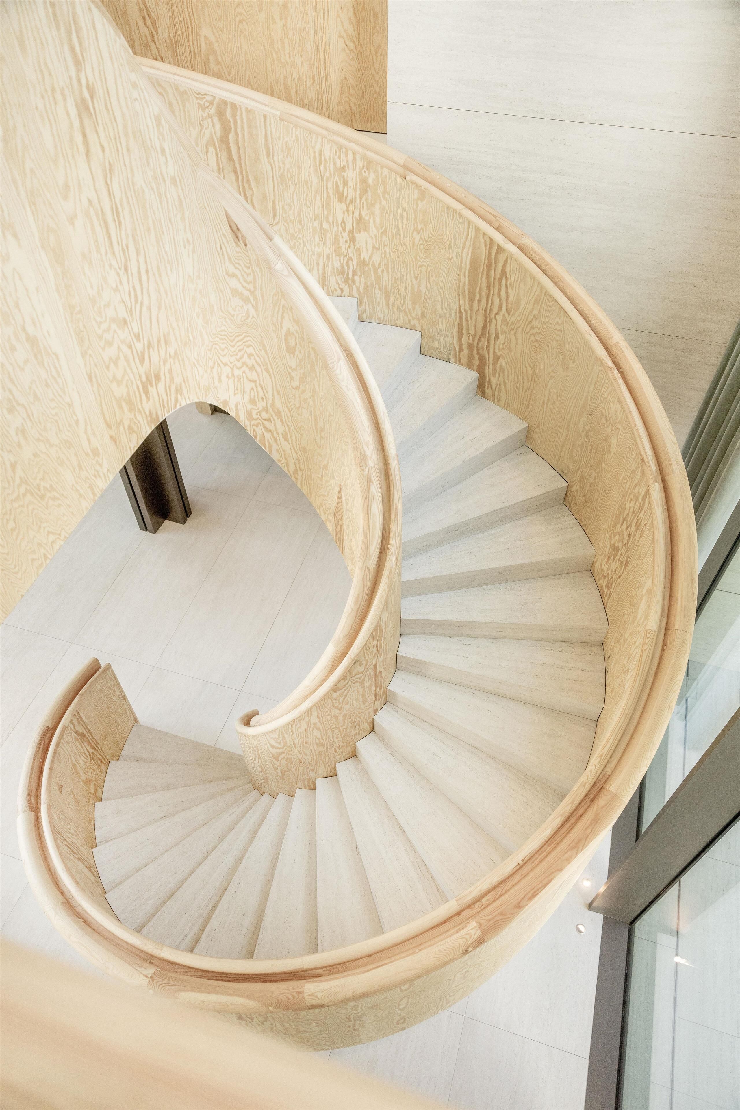 A spiral staircase with wooden steps and a wooden railing.