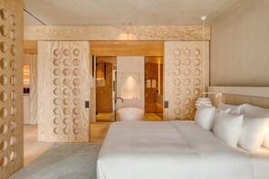 A modern hotel room with a large bed, a round mirror, and a wooden wall with circular cutouts. - Radisson Collection The National Hotel, Brussels (Zaventem)