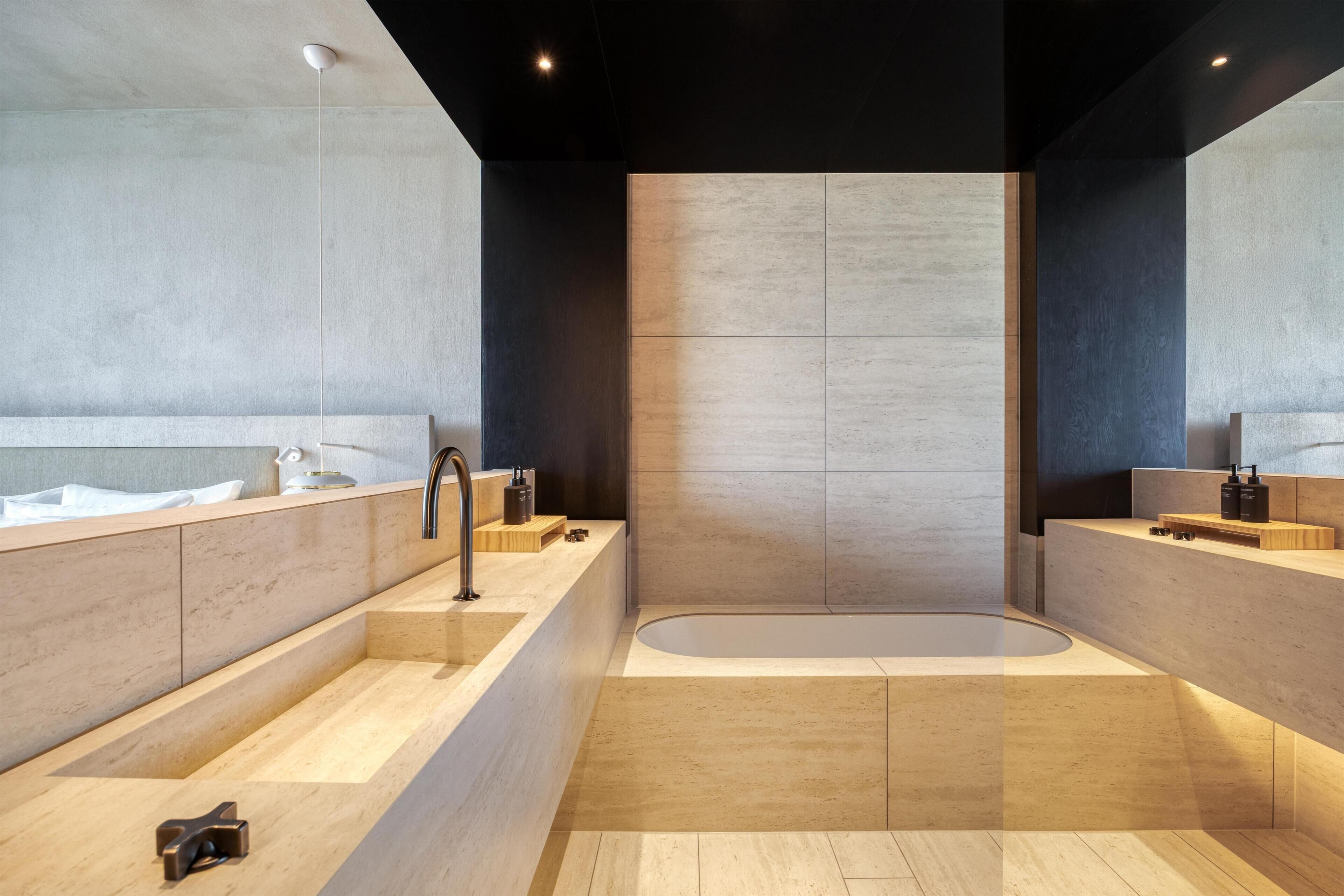 Un baño moderno con una bañera grande, un lavamanos y un espejo.