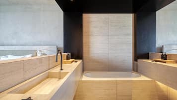 Un baño moderno con una bañera grande, un lavamanos y un espejo.