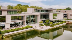 A modern building with a courtyard and a reflective water feature. - Radisson Collection The National Hotel, Brussels (Zaventem)