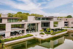 A modern building with a courtyard and a reflective water feature. - Radisson Collection The National Hotel, Brussels (Zaventem)