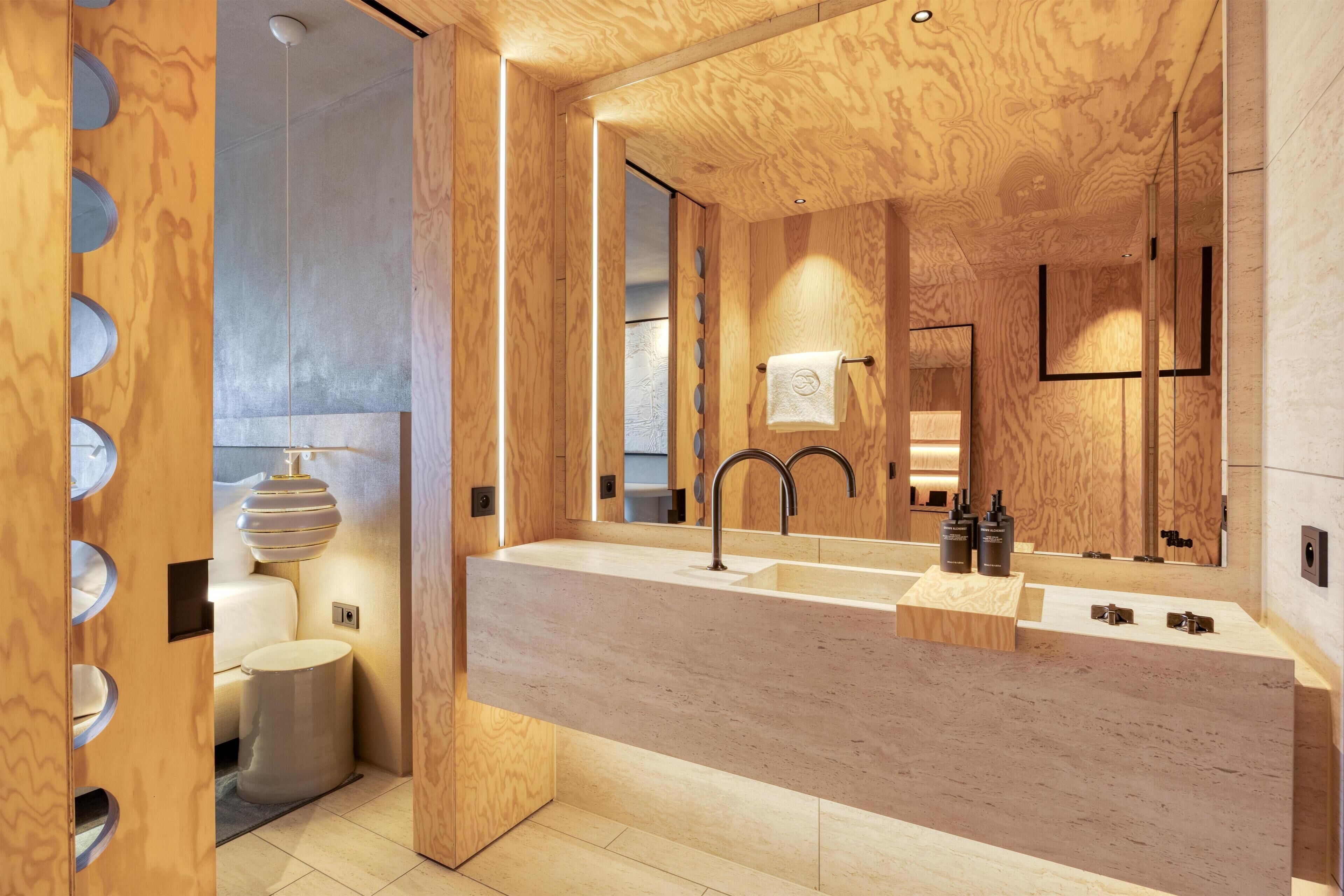 A modern bathroom with a wooden vanity, a sink, and a mirror.