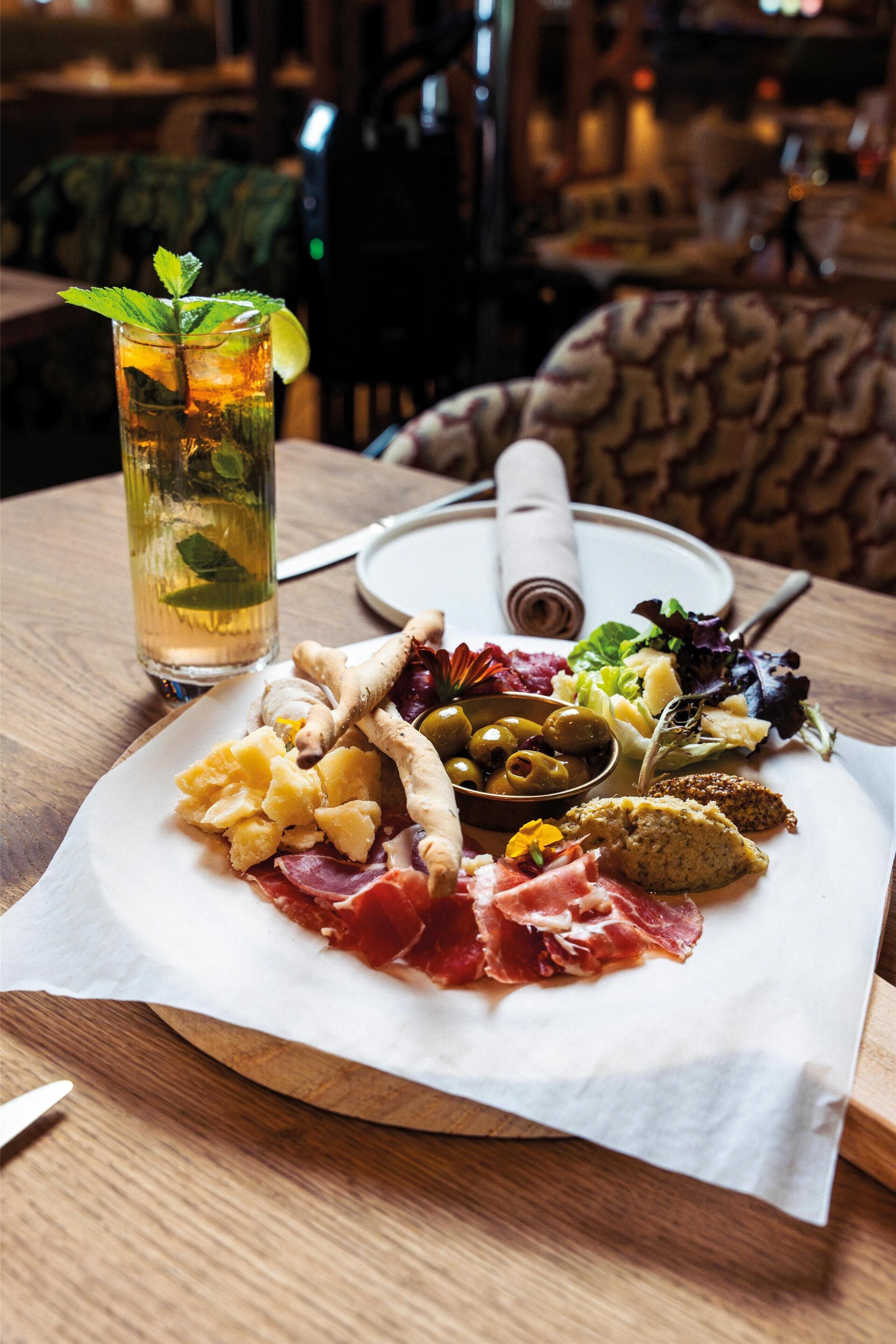 Ein Holztisch mit Essen, einem Getränk und einem Servietttuch.