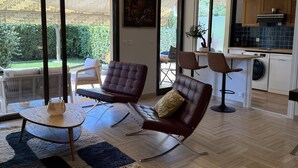 A spacious living area with modern furniture, large windows, and a view of the outdoors. - Studio with direct access to the sea and swimming pool in a green setting (Villeneuve-Loubet)