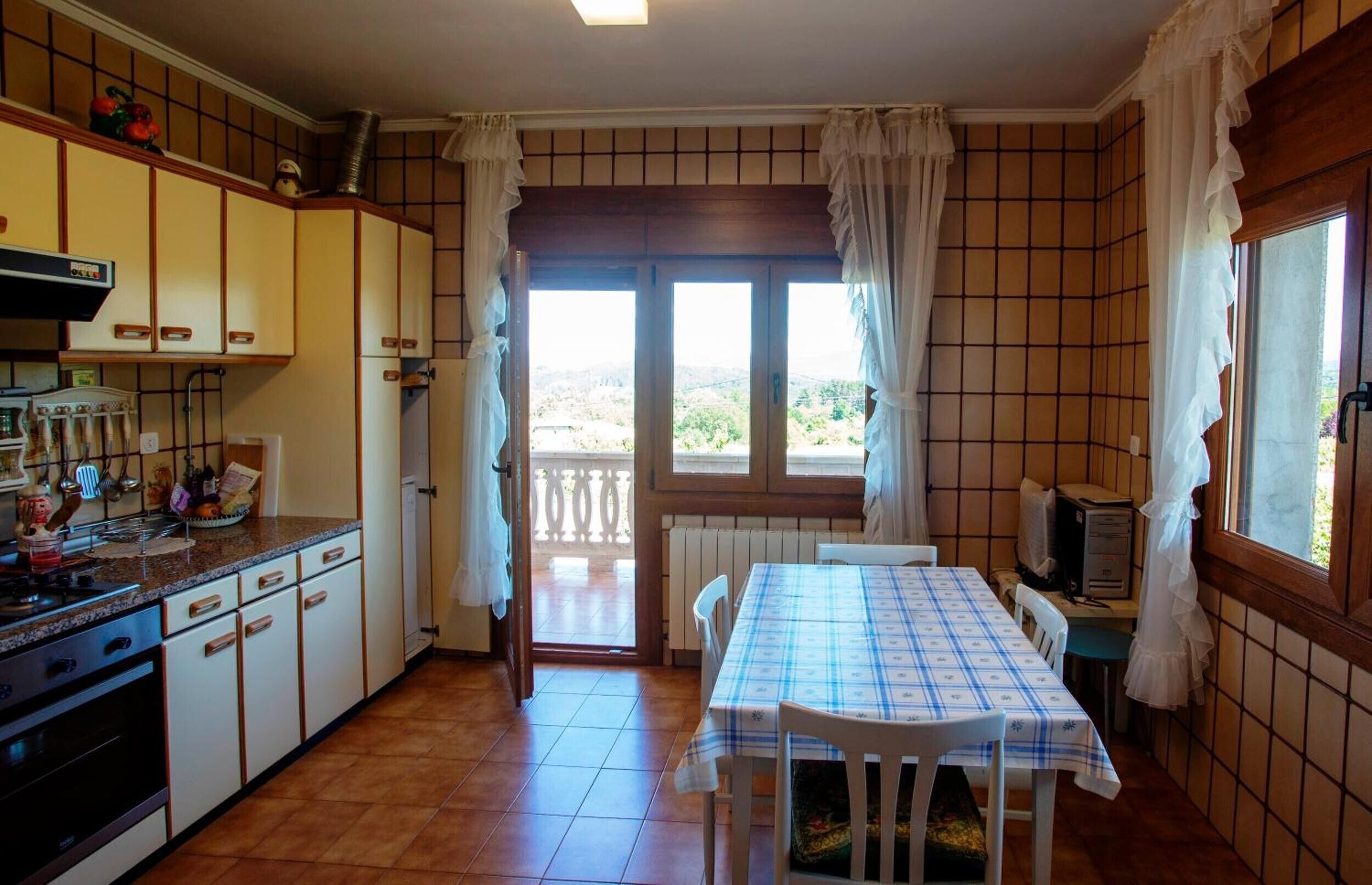 A kitchen with a dining area, a view through the window, and a radiator.