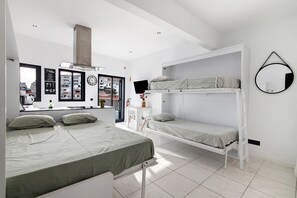 Ein modernes Schlafzimmer mit Etagenbett, Schreibtisch und großem Fenster.