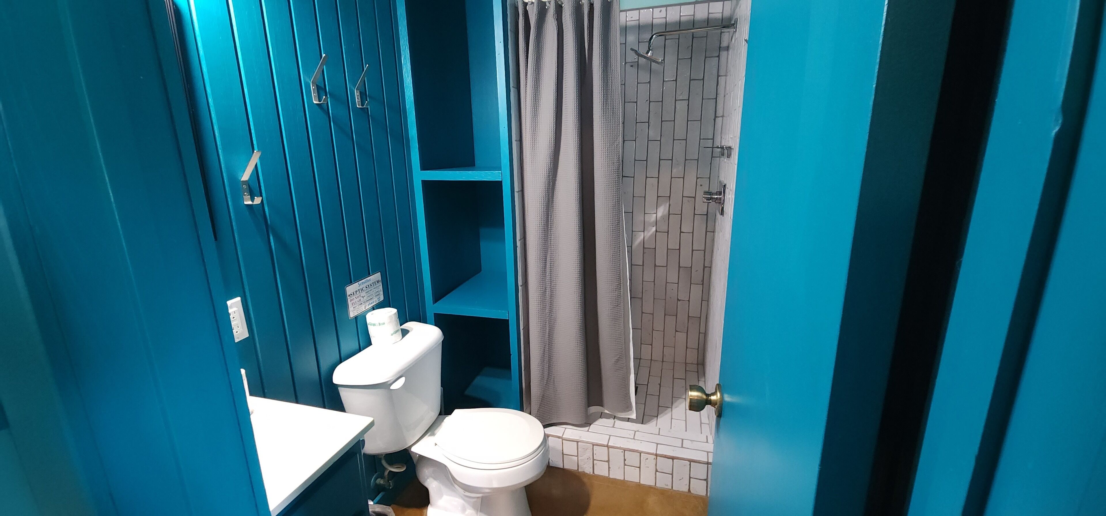 Une salle de bain comprenant des toilettes, un lavabo et un espace douche.