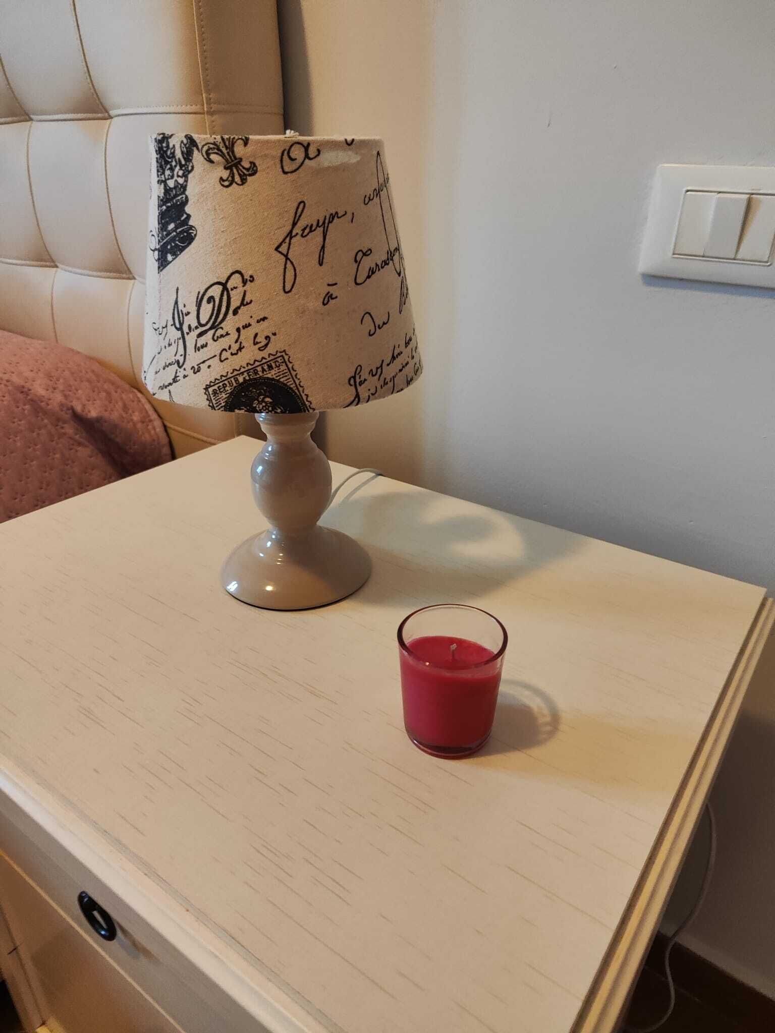 Ein Nachttisch mit Lampe und Kerze.