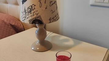 Ein Nachttisch mit Lampe und Kerze.