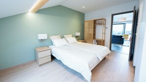 A modern bedroom with a bed, bedside tables, and a wooden wardrobe.