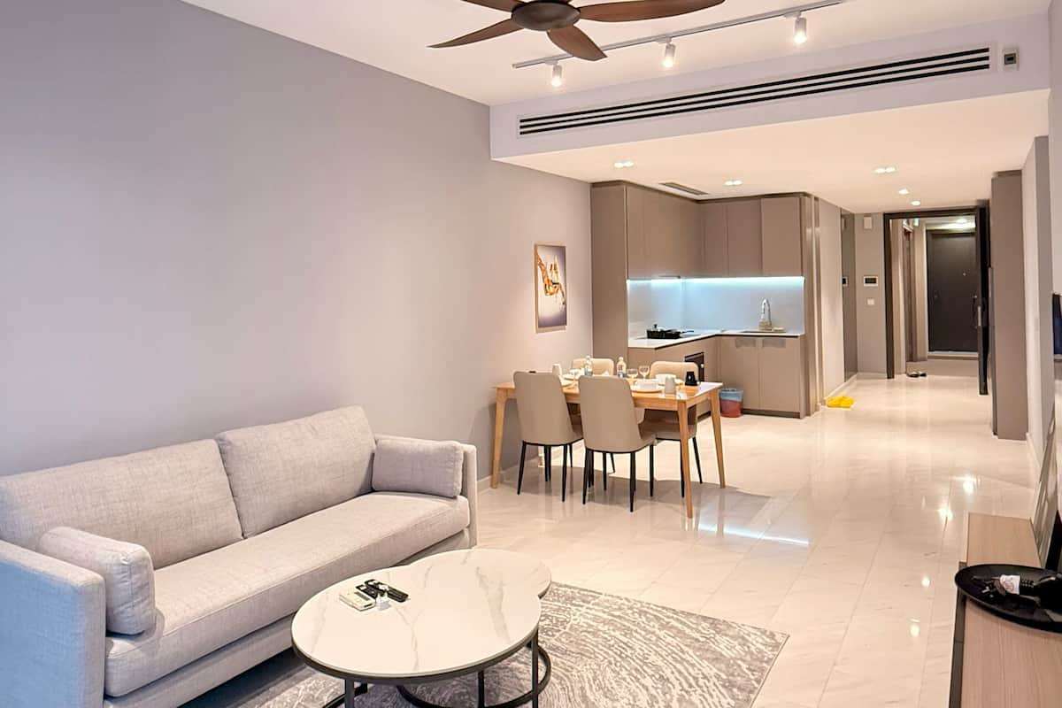 A modern living room with a sofa, coffee table, and dining area.