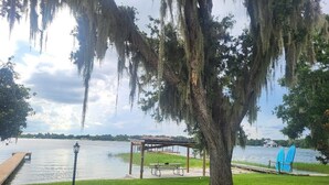 A lakeside park with a gazebo, picnic table, and a dock extending into the water.