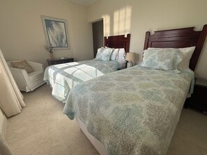 A hotel room with two beds, a nightstand, a chair, and a painting on the wall. - Jack's Place - by Zenbreak (Mullins)