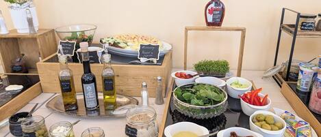 A buffet table with various food items and condiments.