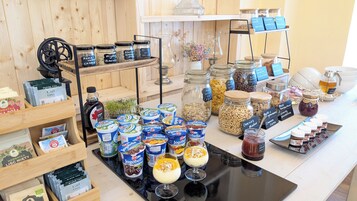 Diversos alimentos y bebidas, incluyendo tarros de nueces, cereales y miel, expuestos sobre un mostrador.