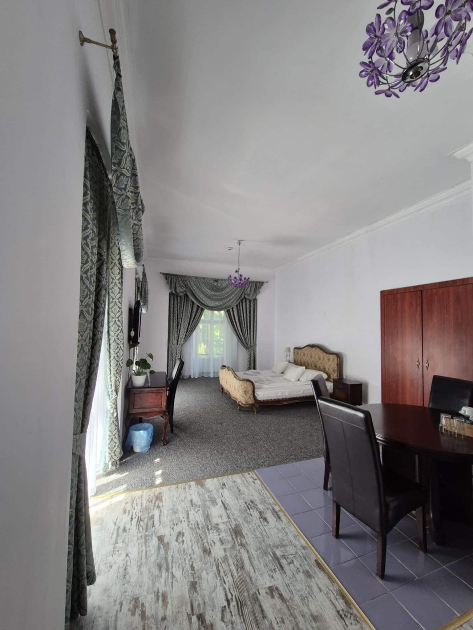 A bedroom with a bed, a desk, and a wardrobe.